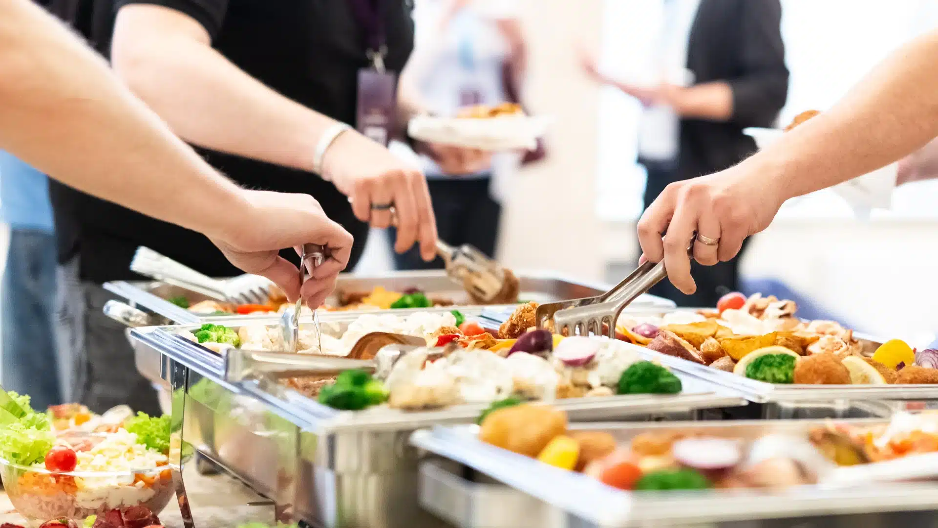 Guests eating food from the buffet catering table at the party